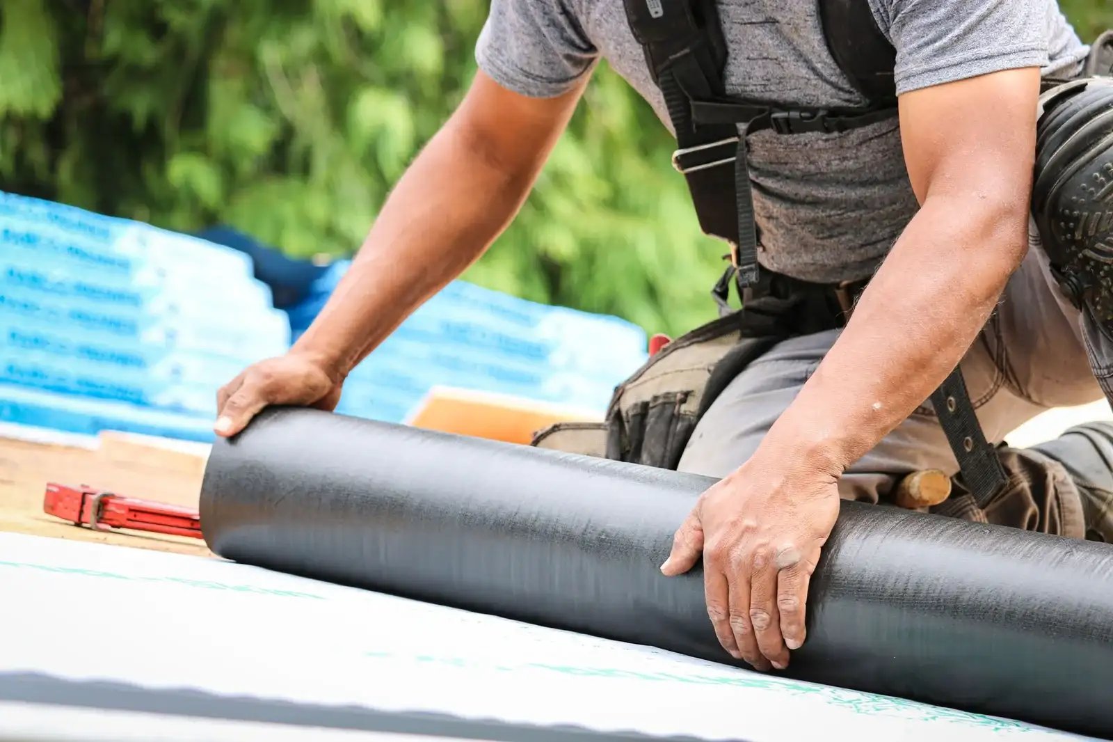 Professional roofing contractor installing roof felt water barrier in Longview, WA